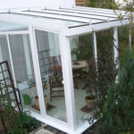 mały ogród zimowy z drewnianymi krzesłami